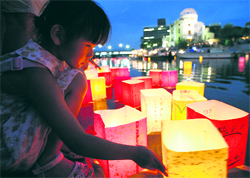 A girl releases a paper lantern on the Motoyasu river in remembrance of atomic bomb victims on the 64th anniversary of the bombing of Hiroshima on Thursday.
