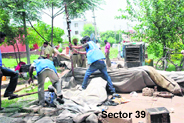 Municipal corporation staff remove “tents” put up by the security personnel in grounds adjoining houses of top officials in Chandigarh on Friday.