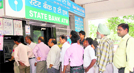 People queue up outside an ATM in Sector 17 to withdraw cash on Friday.