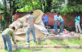 The enforcement staff of the municipal corporation remove a security tent from Sector 7 in Chandigarh on Saturday.