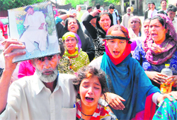 Relatives of Meharj-u-Din Sheikh, who was allegedly killed in police custody, hold a protest in Srinagar on Saturday.