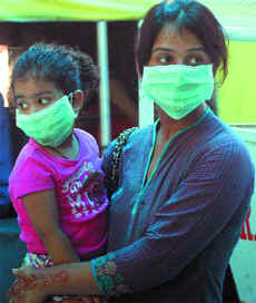 A woman and her kid outside the screening centre of Ram Manohar Lohia Hospital in New Delhi on Sunday.