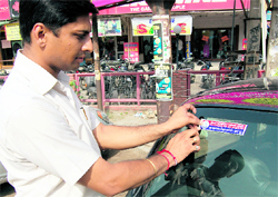 A sticker raising awareness on the police verification programme being pasted on a vehicle in Ludhiana.
