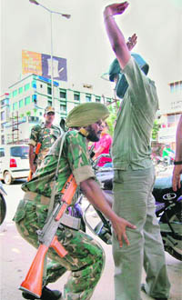 A security man frisks a biker at Bhangagarh in Guwahati on Monday ahead of Independence Day.