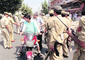 Cops stop motorists at a barricade set up to thwart a separatist All-Party Hurriyat (Freedom) Conference (APHC) march in Srinagar