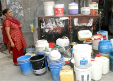  A woman surrounded by plastic containers, waits for her turn in Jalandhar.