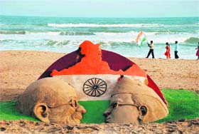 A sand sculpture created by students of sand artist Sudarshan Patnaik ahead of Independence Day at a beach in Puri