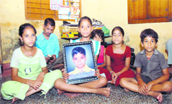 Ashu holds the portrait of her sister Diksha who was murdered in 2004.