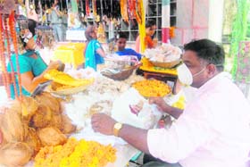 LEAVING LITTLE TO FAITH: A shopkeeper with a mask outside a temple in Dehradun