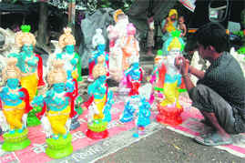 A boy paints an idol of Lord Krishna .