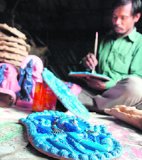 An artiste gives final touches to a Lord Krishna idol, popular with the people during the Janamashtami festival, at his workshop in Shimla on Thursday.