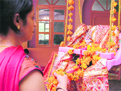 A woman decorates a swing ahead of Janamashtami celebrations in Ludhiana.