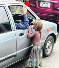 A child begs for alms on a road in Gurgaon on Friday. 