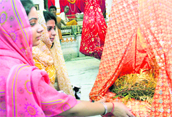Devotees perform puja on the occasion of Janmashtami in a Jammu temple on Friday.
