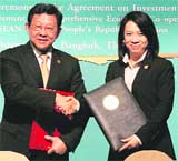 Thai Commerce Minister Pornthiwa Nakasai (R) shakes hands with Chinese Commerce Minister Chen Deming during the signing agreement between the Association of Southeast Asian Nations (ASEAN) and China during the 41st ASEAN Economic Minister Meetings in Bangkok