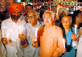 (From left) Rajya Sabha member Tarlochan Singh, senior journalist Kuldip Nayar, a guest from Pakistan and filmmaker Mahesh Bhatt light candles at a function at the Attari-Wagah check post, near Amritsar, on Saturday.