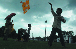 A child flies kite in cloudy weather at the India Gate.