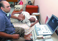 A doctor checks a patient at a free heart check-up camp at Acharya Sushil Muni Ashram in New Delhi on Sunday.