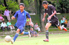 Players vie for the ball during the u-19 District Football Championship at Pavilion Ground on Sunday.