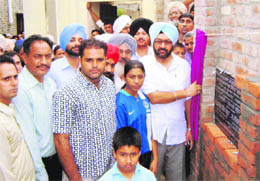 Jasbir Singh Khangura lays the foundation stone of a house for Jagdeep Kaur at Butahri village. 