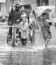 A rickshawpuller wades through a waterlogged street in Patna on Sunday.