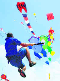 Kites lift a man as he flies them during an international kite festival in Cartagena on Saturday.