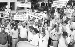Members of the Mohali Industries Association stage protest outside the office of the Deputy Commissioner in Mohali 
