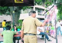 A university employee removes posters of students organisations from a notice board at the student centre in Panjab University 
