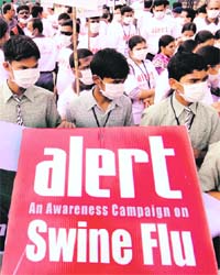Schoolchildren hold a banner during a H1N1 awareness rally in Hyderabad