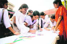 Students take part in a signature campaign for the setting up of the proposed central university in the Jammu region at the main gate of Government College for Women in Jammu on Monday.