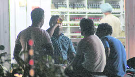A youth consumes beer while sitting on a motorcycle outside a liquor vend in Sarabha Nagar in Ludhiana.