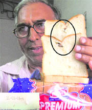 Consumer shows insects in slices of bread manufactured by a reputed company.
