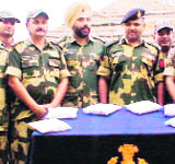 BSF personnel with seized heroin on the Indo-Pak border on Monday. 