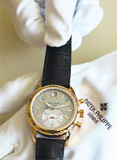 An employee displays a Patek Philippe chronograph rf. 5960 in an atelier at the Swiss watchmaker manufacture in Plan-Les-Ouates near Geneva on Monday. Patek Philippe, one of the last major independent Swiss watchmakers, expects sales to rise in 2009 as the super rich shrug off the worst economic crisis in decades and splash out on top-end watches. 
