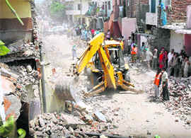 A JCB machine carries out demolition at Ram Darbar in Chandigarh on Tuesday.