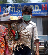 As a precautionary measure against swine flu, a bhelpuri seller wears a mask at the Civil Hospital in Gurgaon on Tuesday.