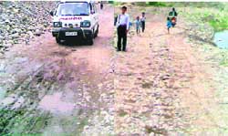 A private ambulance crosses the Ujh riverbed to take a patient from Chak Chhaba village to Kathua; and (right) Children cross the Bagh nullah to reach home.