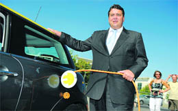 German Federal Minister Sigmar Gabriel holds a charging cable next to an experimental electric car in Berlin on Wednesday. The German government unveiled plans to get a million electric cars zipping around the country by 2020, offering compensation to jump-start national giants like BMW and Volkswagen into action.