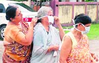 Relatives of swine flu victim Ronak Singh put masks before going to his house to condole his death in Dehradun 