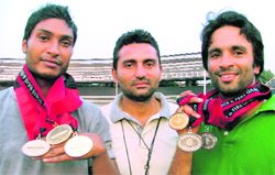 Athletes Amritpal (left) and Gurpreet Singh (extreme right), along with there coach Sanjeev Kumar, who won medals in World Police Games held in Canada, in Ludhiana on Wednesday. 