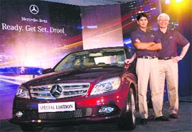Mercedes-Benz India CEO Wilfried G. Aulbur (R) poses with newly launched Mercedes Benzs Special Edition C-class and golfer Gaganjeet Singh Bhullar after presenting him the keys of the car in New Delhi