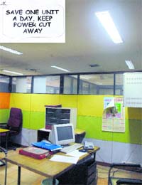 An empty cabin with lights on during a strike by BSNL officials in Chandigarh; and (inset) a poster carrying a slogan on saving electricity put up in the building