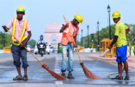 Workers of the Delhi Metro clean the Rajpath as part of an ongoing Metro project in New Delhi on Thursday.