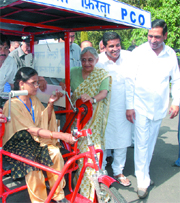 Chief Minister Sheila Dikshit gives a 'Chalta-Firta PCO' to a physically challenged woman in memory of the late Prime Minister Rajiv Gandhi in New Delhi on Thursday. 