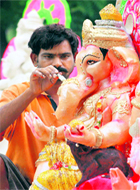 An artist gives final touches to an idol ahead of the Ganesh festival at Bathinda on Thursday.