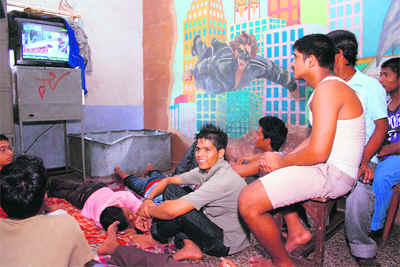 Salim watches TV with friends at the home for the homeless