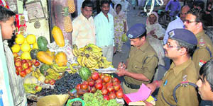 Policemen verify details of encroachers at Jwalapur market in Haridwar on Saturday.