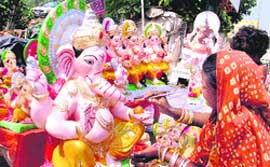 An artist gives finishing touches to an idol of Lord Ganesha, ahead of Ganesh Chaturthi in Ludhiana