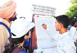 People participate in a signature campaign organised by an NGO to promote water conservation at Sukhna Lake on Sunday. 