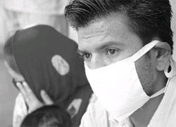 A patient wears a mask in view of swine flue threat at a hospital in Patiala on Sunday. 